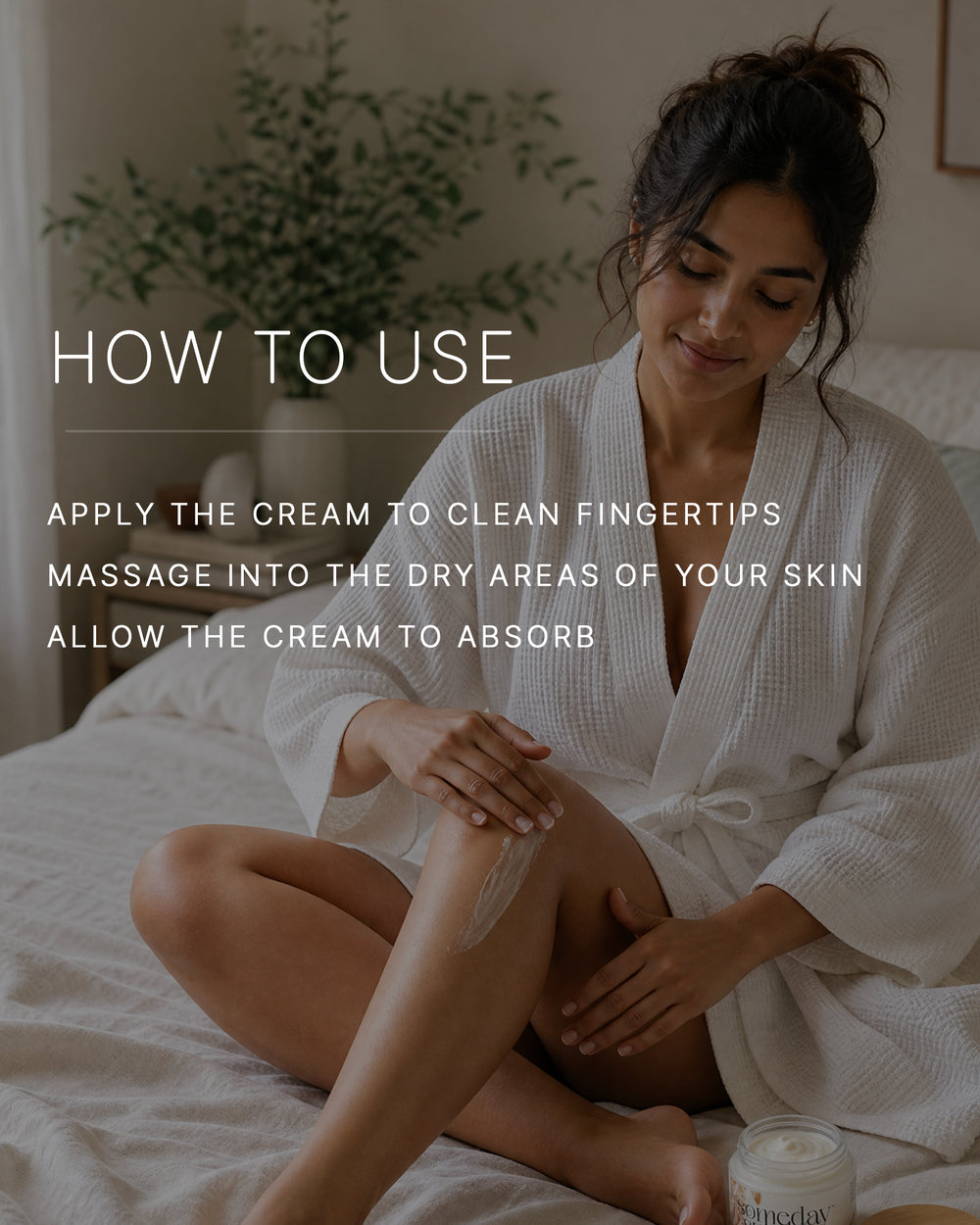 How to use. Apply the cream to clean fingertips. Massage into the dry areas of your skin. Allow the cream to absorb. A woman with a medium skin tone in a white waffle robe sits cross-legged on a bed, massaging body cream into her lower leg in soft morning light.