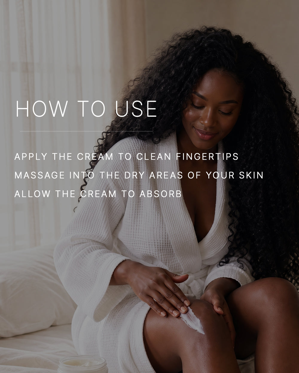 How to use. Apply the cream to clean fingertips. Massage into the dry areas of your skin. Allow the cream to absorb. A woman with a deep skin tone and long curly black hair, in a white waffle robe, sits on a bed massaging body cream into her knee.