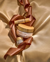The Someday Sunday Vanilla Embrace trio: body cream, lip butter jar and lip butter stick.